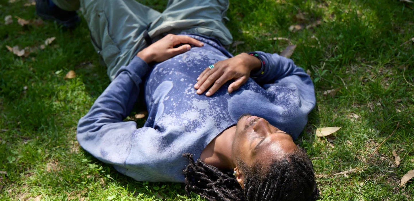Image of a man laying down outside on grass