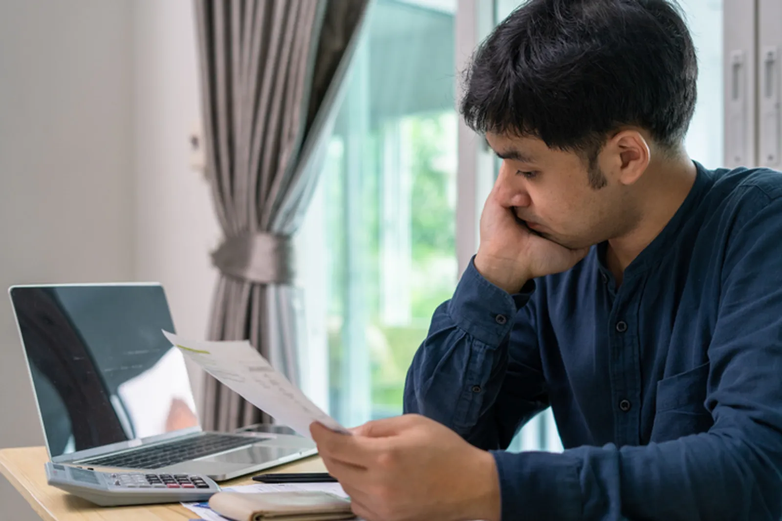 Men stress about a lot of credit card debt and bills on the floor. The housewife has trouble calculating monthly expenses and the budget is not enough to pay off the debt