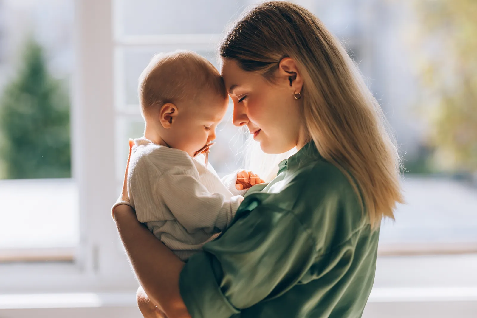 The image features a woman holding a baby close to her chest, providing a sense of warmth and love.