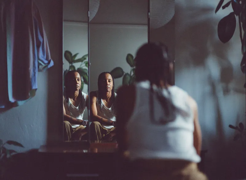 a person looks at their reflection in a mirror