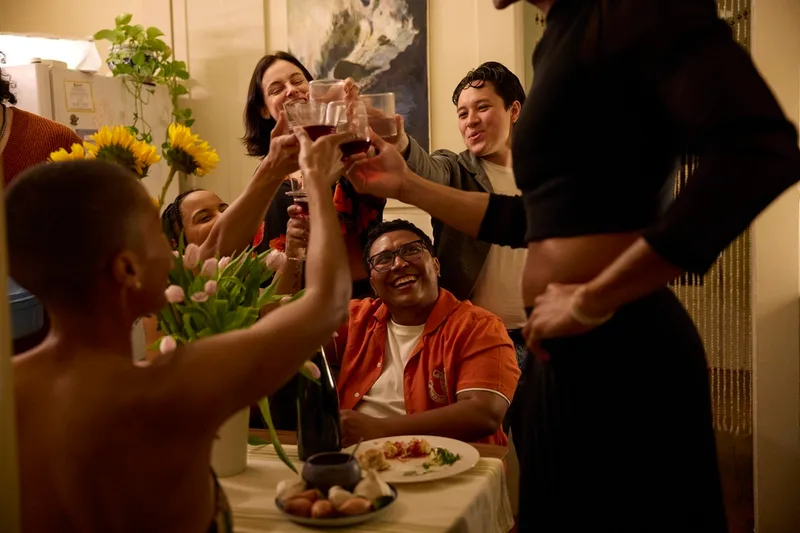 a group of people cheers each other at a dinner table