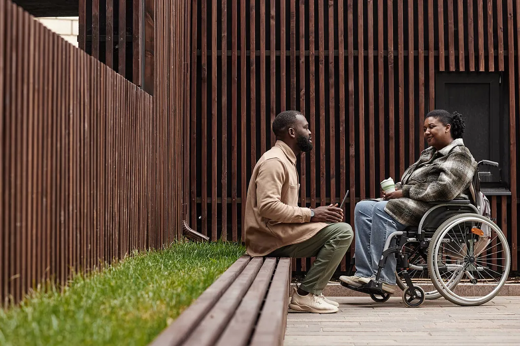 Woman who uses a wheelchair and a man sitting and talking