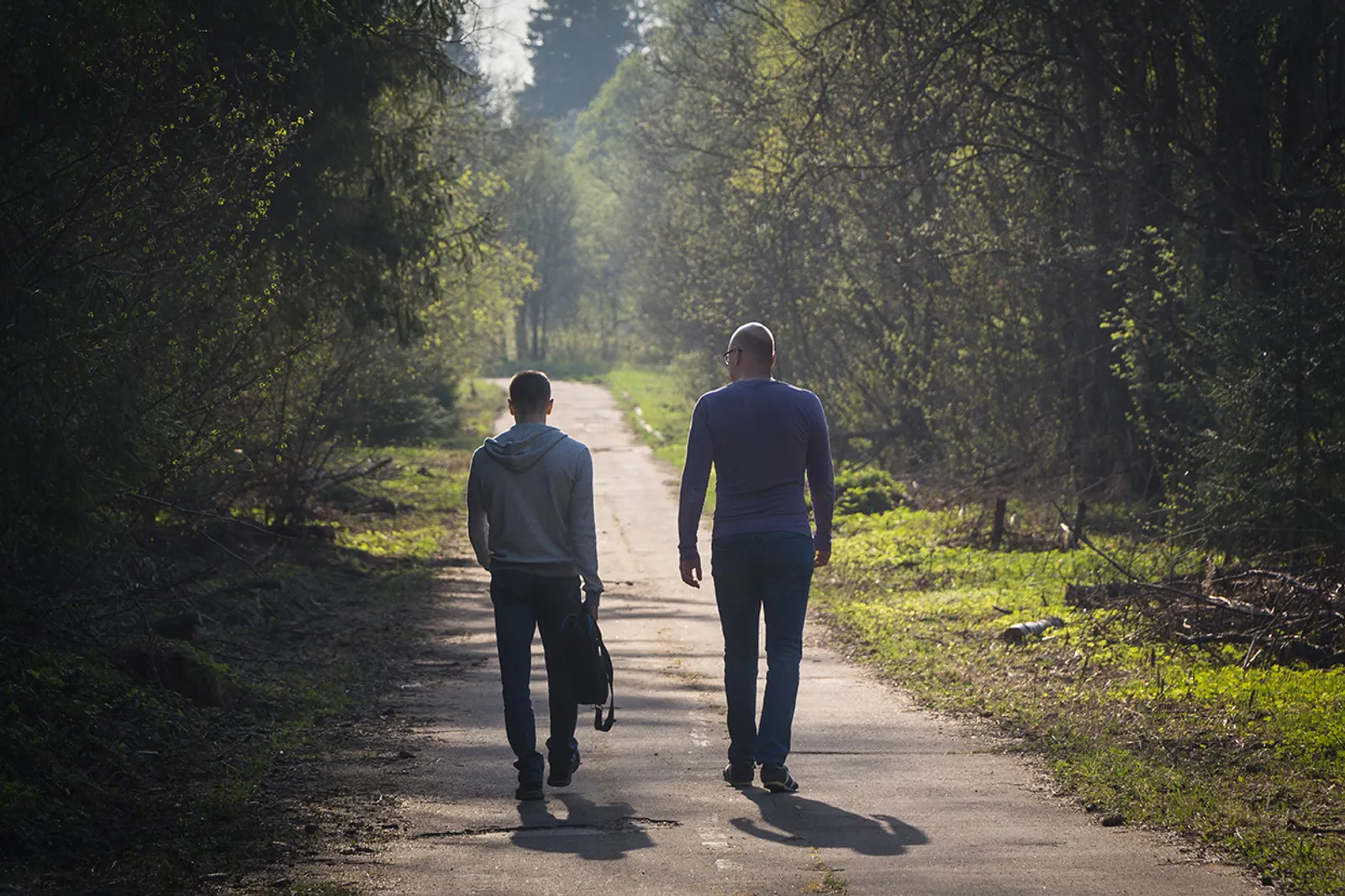 Two people walking outside on a trail