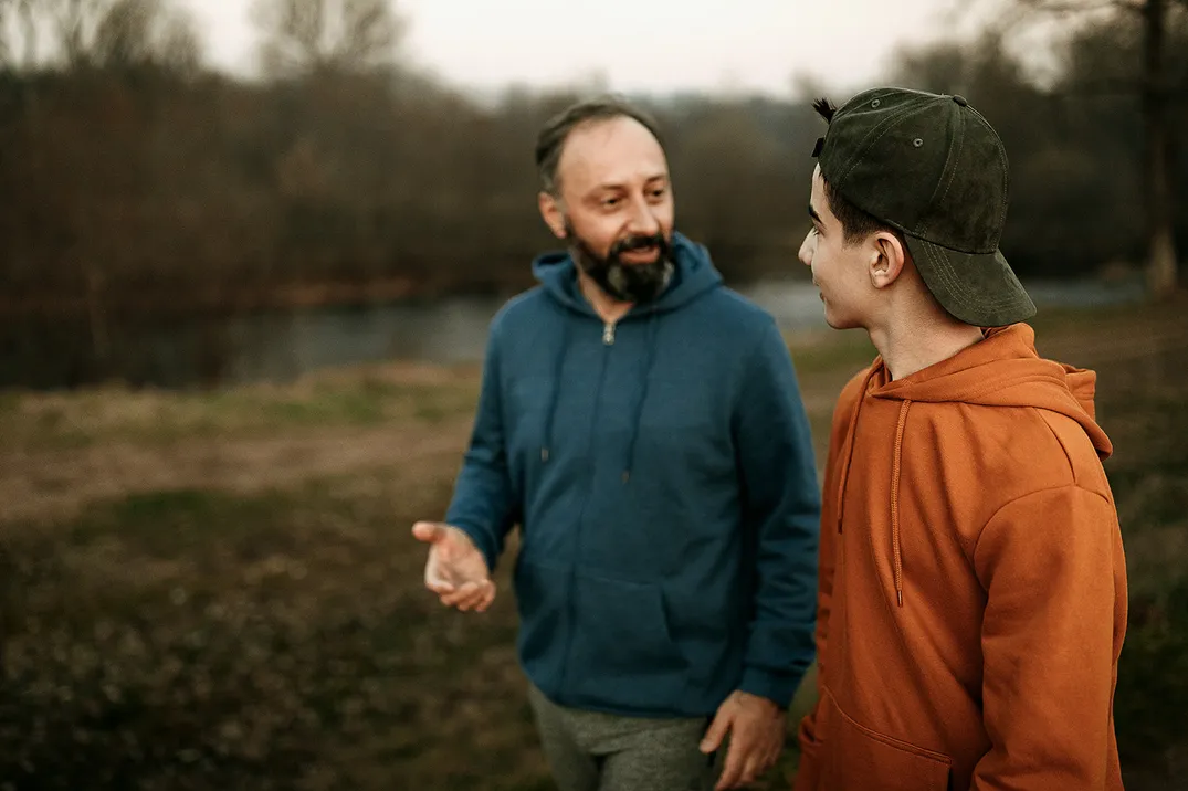 Man and younger son walking and talking
