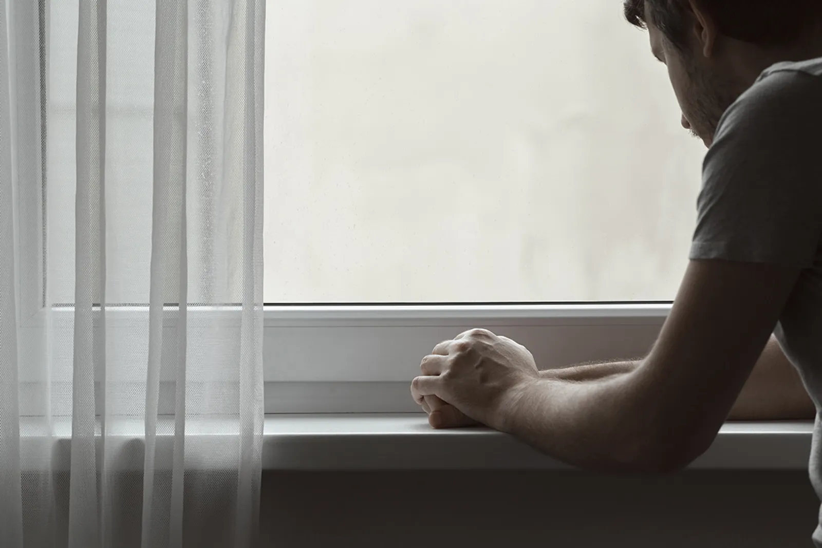 Man leaning and looking out the window