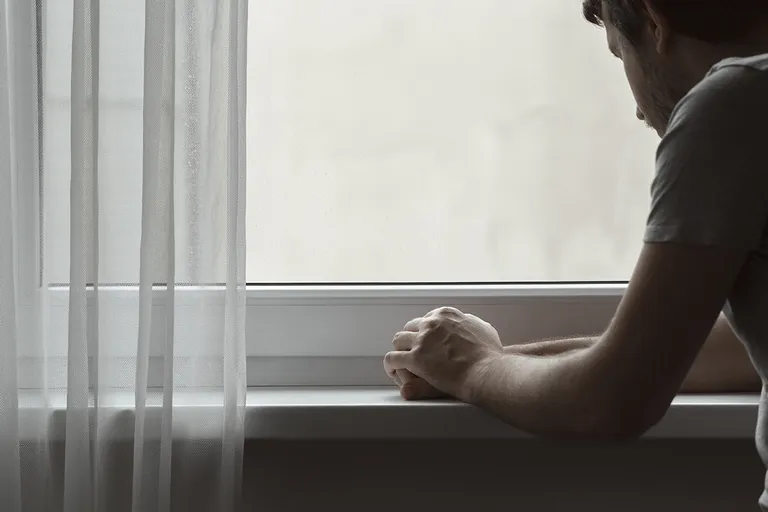 Man leaning and looking out the window