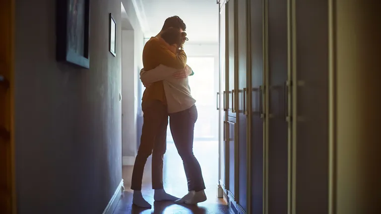 Two people hugging in a hallway